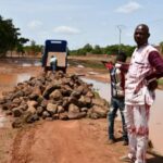 Un habitant de Solenzo répare une portion de route dégradée